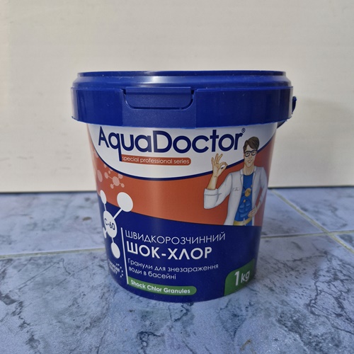 Blue-lidded AquaDoctor pool chemical bucket with Ukrainian label, 1 kg Sold for shock chlorine tablets/granules (doctor illustration on label).